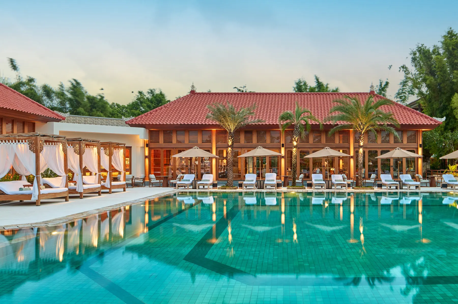 Resort pool with poolside cabanas at dusk